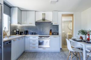 a kitchen with white cabinets and a stove top oven at Solea Cottage - Bright Escape in Skopelos in Skopelos Town