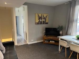 a living room with a television and a table with chairs at Berridge House in Nottingham