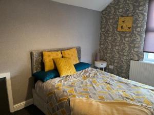 a bedroom with a bed with yellow and blue pillows at Berridge House in Nottingham
