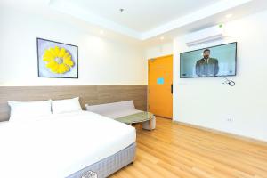 a bedroom with a bed and a tv on a wall at TMS-PULLMAN MINH MINH Apartment in Quy Nhon +25 photos