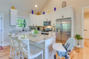 a kitchen with white cabinets and a island with bar stools at Modern Hendersonville Home Deck and Mountain Views! in Hendersonville +15 photos