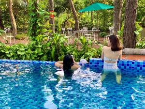 two women in the water in a swimming pool at Pine Hill Villas & Camping in Sóc Sơn