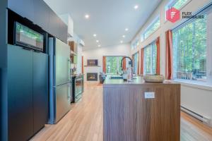 a kitchen with a large island in a house at L'Orange-Méridien de Portneuf / Extra-Comfort, Hot tub and Pool in Pont-Rouge +49 photos