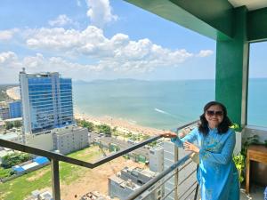 een vrouw op een balkon met uitzicht op de oceaan bij ZoZo House - Homestay Bai Sau - bien Vung Tau in Vung Tau