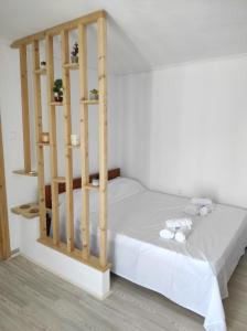 a bedroom with a wooden bed with white sheets at Θέα από ψηλά in Áyioi Apóstoloi