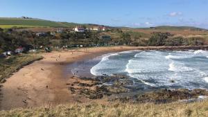 an aerial view of a beach with people and the ocean at Pettico Lodge in Eyemouth