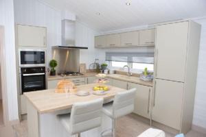 a white kitchen with a table and chairs in it at The Sands in Coldingham