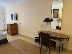 a room with a desk with a lamp and a mirror at Bianchi Hotel in Alexandria