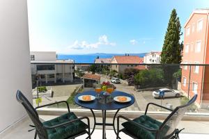 a table and chairs on a balcony with a view at Apartments Diva in Trogir