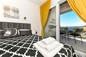 a bedroom with a black and white bed and a balcony at Apartments Diva in Trogir
