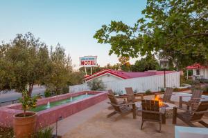 a patio with a fire pit and a motel sign at Farmhouse Paso in Paso Robles