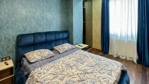 a bedroom with a bed with a blue head board at Downtown Residence in Tbilisi City +37 photos