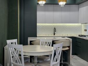 a kitchen with a white table and chairs at Downtown Residence in Tbilisi City