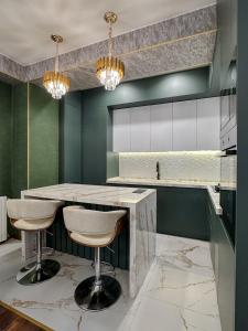 a kitchen with a marble counter and stools at Downtown Residence in Tbilisi City