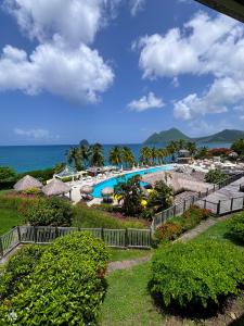vista su un resort con piscina e oceano di Studio Ti Saphir a Le Diamant