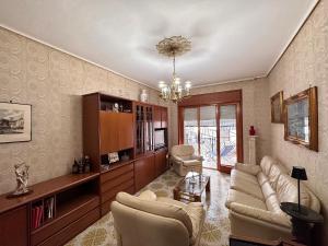 sala de estar con sofá, sillas y lámpara de araña en Alfa Holidays, en Sorrento