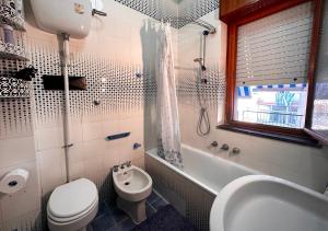 Un baño con inodoro, lavabo y bañera. en Alfa Holidays, en Sorrento 11 fotos más