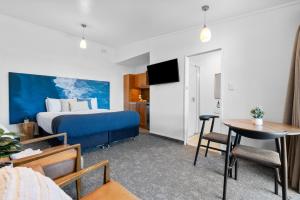 ein Hotelzimmer mit einem Bett und einem Tisch in der Unterkunft Tasman Holiday Parks - Waihi Beach in Waihi Beach