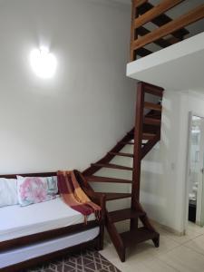 a spiral staircase in a room with a bed at Lofts Primavera Centro Histórico Paraty in Paraty