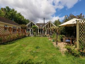 a yard with a house and an umbrella at Little Timbers in Ringwood