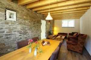 sala de estar con mesa y pared de piedra en Alte Scheune Bruns en Lehmen