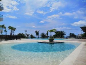 una piscina con agua azul y palmeras en Sensacional! Apartamento Cartagena Morros Sonesta, en Cartagena de Indias