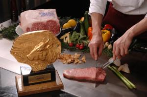 a person cutting meat on a table with a trophy at ANA Crowne Plaza Kobe, an IHG Hotel in Kobe