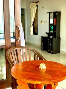 a wooden table and chair in a room at Titi Sedana Homestay in Amed
