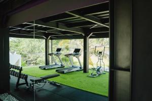 a gym with several treadmills and exercise machines at Deluxe apartments Canggu area with gym coworking security parking and full services in Tumbak Bayuh