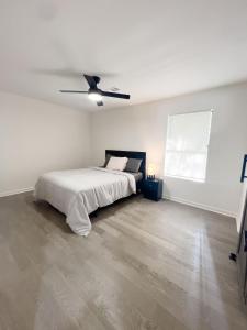 una camera da letto bianca con un letto e un ventilatore a soffitto di Cozy Contemporary Bungalow a Decatur