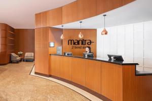a woman sitting at a counter in a waiting room at Mantra 2 Bond Street in Sydney +118 photos