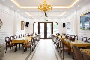 a dining room with tables and chairs and a chandelier at Charming Hill Hotel in Cat Ba