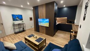 a living room with a blue couch and a table at Apartament centrum in Zabrze