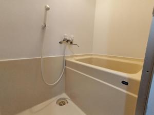 a bath tub with a hose attached to a shower at 65 两室一厅 駒込站4分 近商业街 2 rooms 4 mins to ST Max 7P 直达新宿 涉谷 表参道 池袋 上野 代代木 银座 原宿 in Tokyo