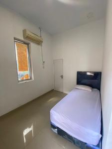 Ένα ή περισσότερα κρεβάτια σε δωμάτιο στο kamar kos
