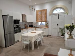 a kitchen with a table and chairs and a refrigerator at Sea & Sky townhouses in Marsaxlokk