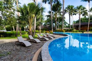 a row of chaise lounge chairs next to a swimming pool at Fridays Puerto Galera in Puerto Galera