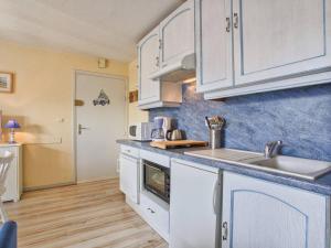 a kitchen with white cabinets and a sink at Charmant T2 à 300m de la plage en Normandie – Balcon, parking et local vélo inclus - FR-1-788-21 in Varaville +5 photos