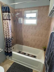 a bath tub in a bathroom with a window at Cozy Stylish Apt New Kingston in Kingston +2 photos