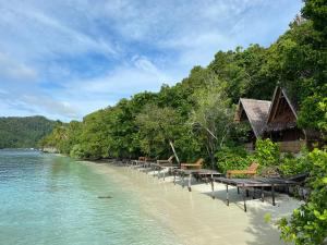 KriWarahnus dive homestay的海滩上设有桌椅