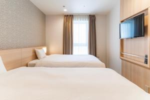Postel nebo postele na pokoji v ubytování Kansai International Airport Hotel 11