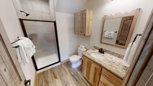 a bathroom with a sink and a toilet and a mirror at Lost in Paradise - Pet Friendly - Hot Tub - WiFi - Fireplace - Grill - On the River - Fire Pit in Red River +18 photos
