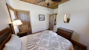 a bedroom with a bed and a ceiling fan at Lost in Paradise - Pet Friendly - Hot Tub - WiFi - Fireplace - Grill - On the River - Fire Pit in Red River