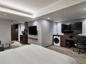 台北市にあるタンゴ ホテル タイペイ リンセンのベッドと薄型テレビがあるホテルの部屋