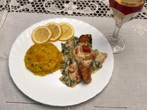 a white plate with food on a table with a glass of wine at Pensiunea Alma Lepsa in Lepşa