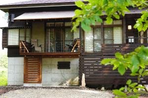 ein Haus mit Terrasse und Balkon in der Unterkunft Pond Cabin Myoko in Myōkō + 14 Fotos