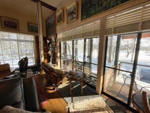 ein Wohnzimmer mit einer Couch und einigen Fenstern in der Unterkunft Pond Cabin Myoko in Myōkō