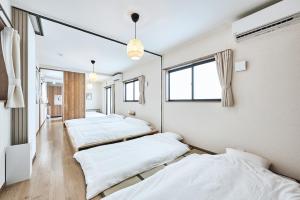 a row of beds in a room with windows at 平宿新町ホテル in Hanabatachō