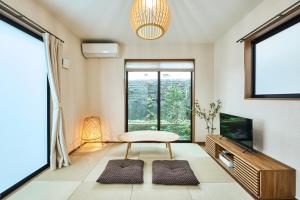 a living room with a table and a window at 平宿新町ホテル in Hanabatachō