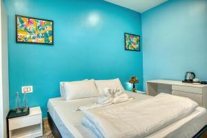 a blue bedroom with a bed with a stuffed animal on it at Michael's Island Resort in Sātpāra